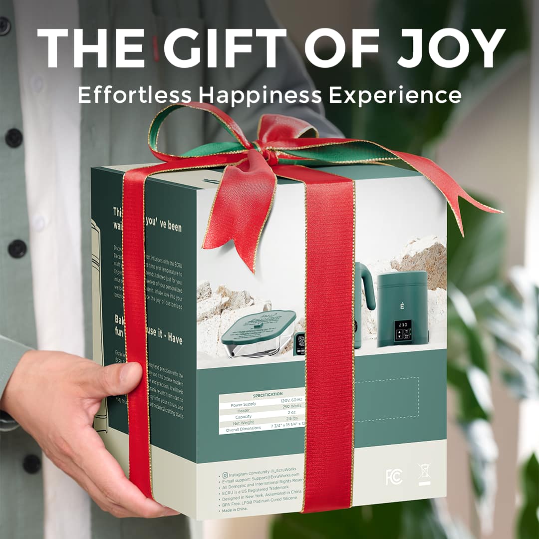 Green ÉCRU gift box tied with a red ribbon, presented in two hands