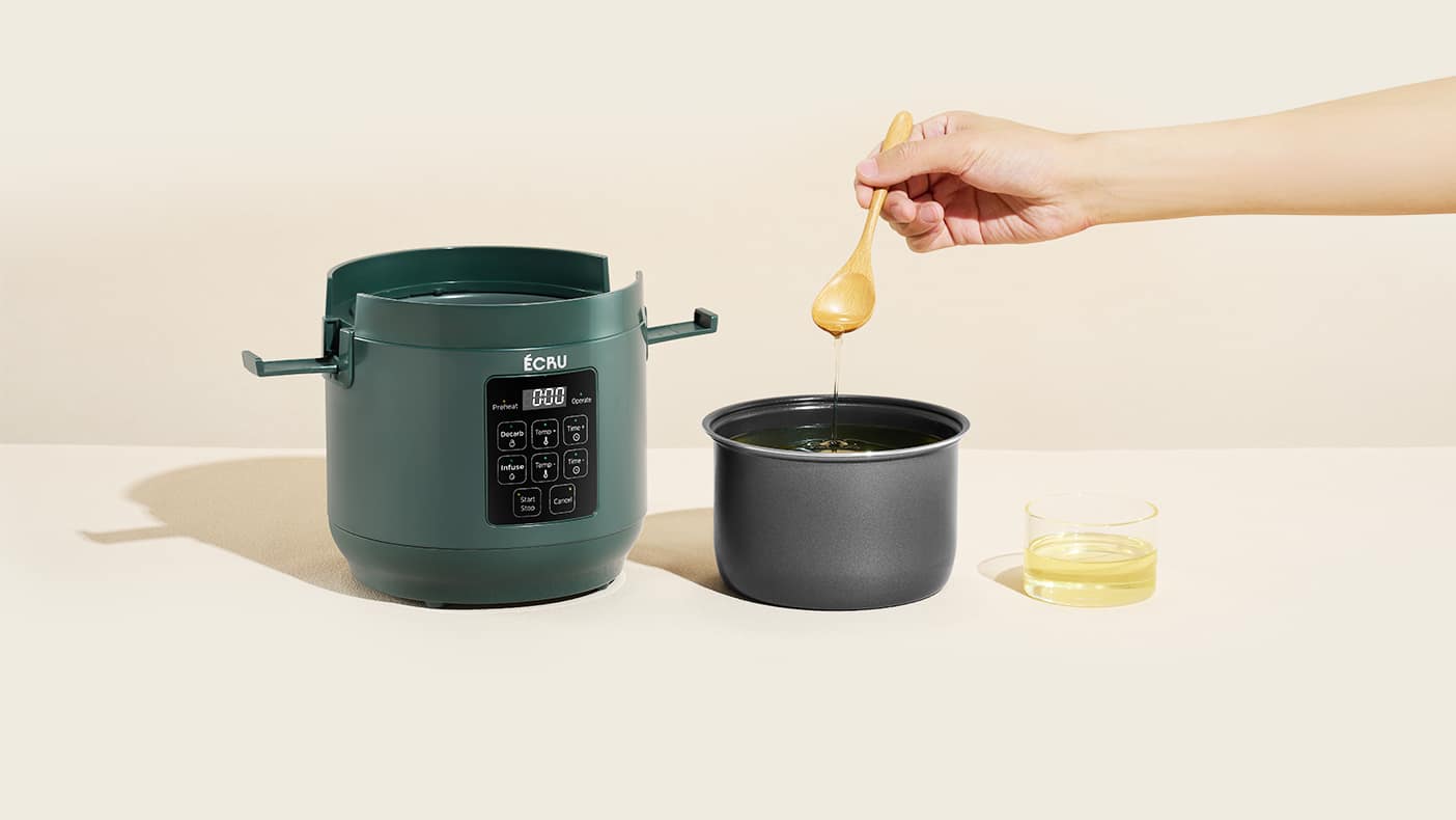 The 3oz unit beside its canister as a dropper lifts finished golden infusion