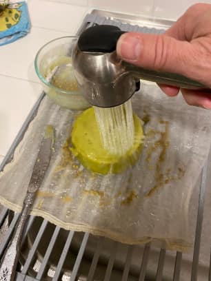 Customer photo: pressing finished infusion through a strainer with a spoon
