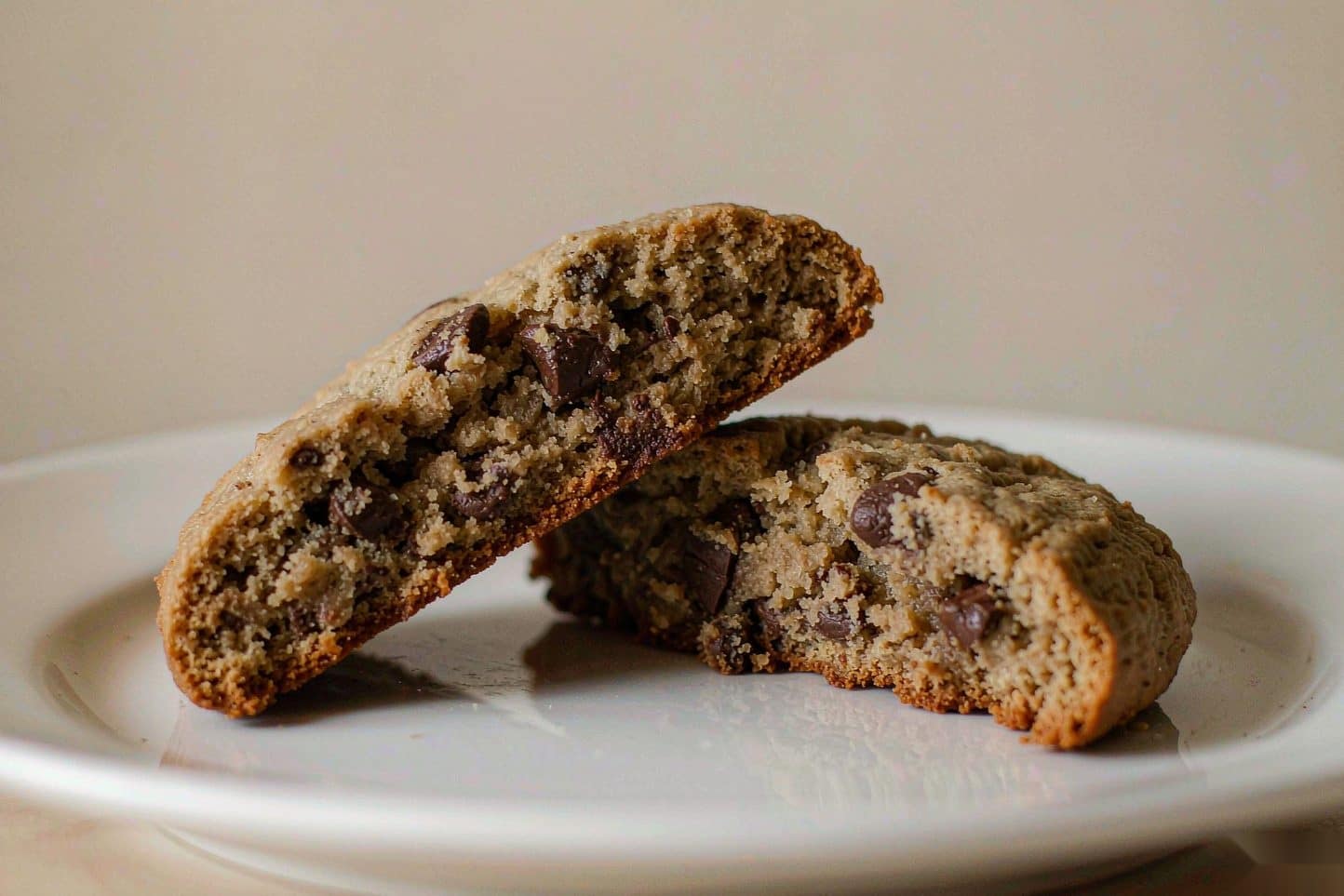 A chocolate chip cookie broken in half showing its soft crumb and melted chips