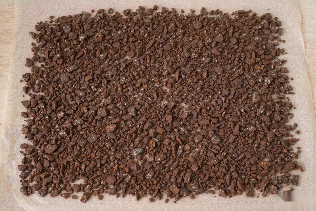Decarbed hash crumbles in an even layer on parchment paper