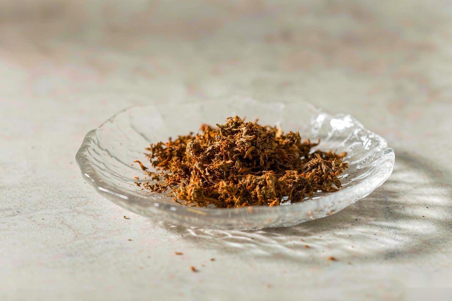 Decarbed cannabis turned golden brown in a small glass dish