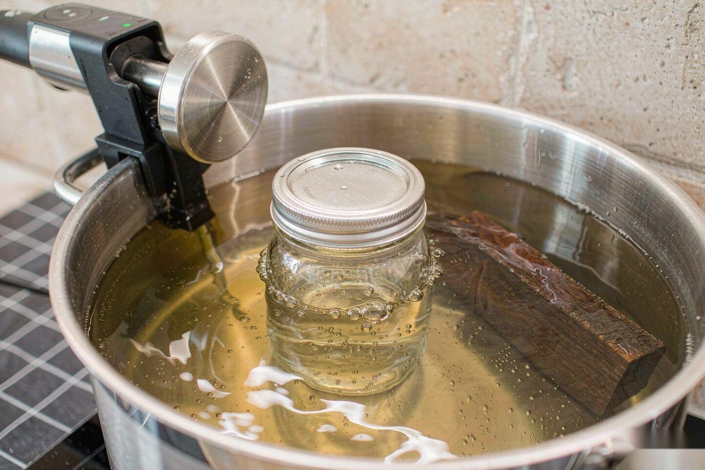Mason jar submerged in a sous vide water bath